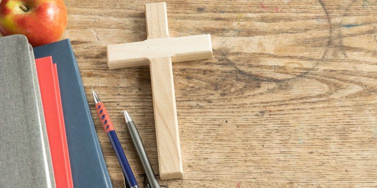 Veteran teacher suspended, faces firing for having cross by desk; law firm says school district violating free speech rights